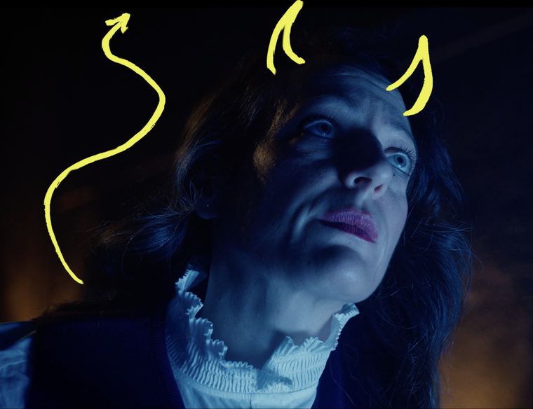 Primer plano con luz azul y cuernos dibujados en amarillo.