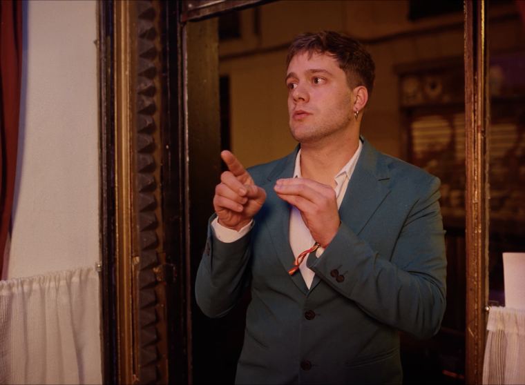 Pelayo, con traje azul, señalando.