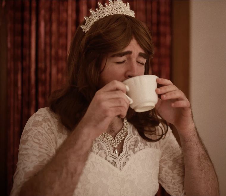 Con corona, bebiendo de una taza.
