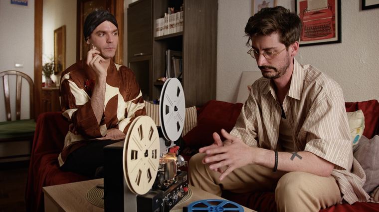 Dos personajes junto a un proyector de cine.