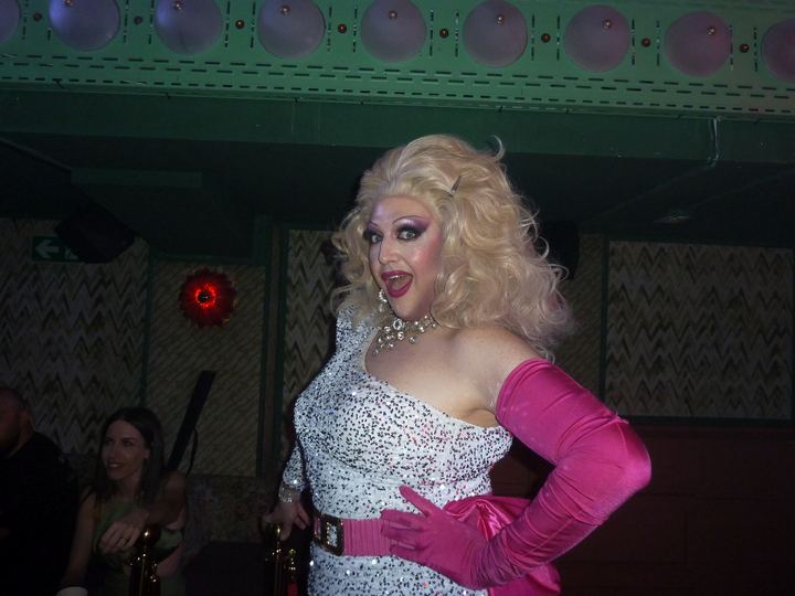 Drag rubia con guantes rosas.