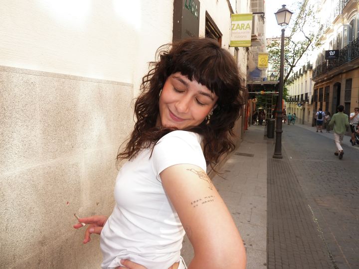 Amaia en la calle enseñando un tatuaje.