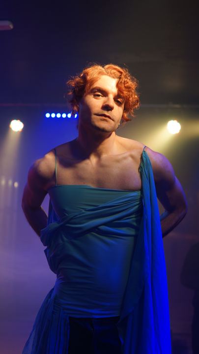 Cere con vestido azul sobre un escenario.