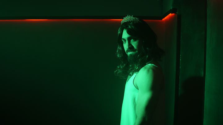 Luis con corona bajo luz verde.