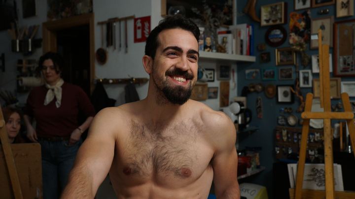 Luis, sin camiseta, en un taller.
