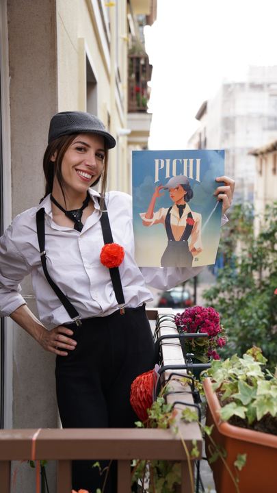 Luna en un balcón, con gorra, tirantes y clavel.